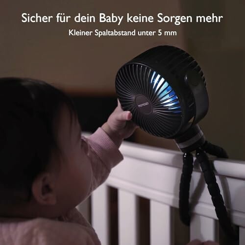 Baby betrachtet einen sicheren Ventilator auf dem Kinderbett.