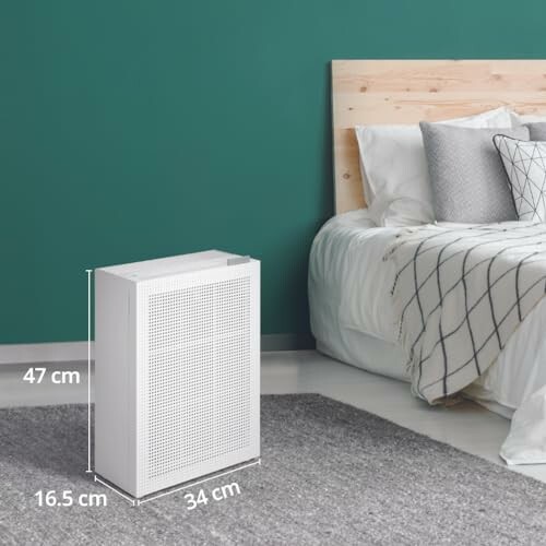 Luftreiniger in einem modernen Schlafzimmer mit grünem Akzent.
