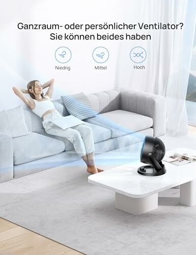 Frau entspannt sich mit Ventilator im Wohnzimmer.